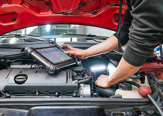 Technician checking a vehicle's starting and charging system under the hood in Kyle, TX